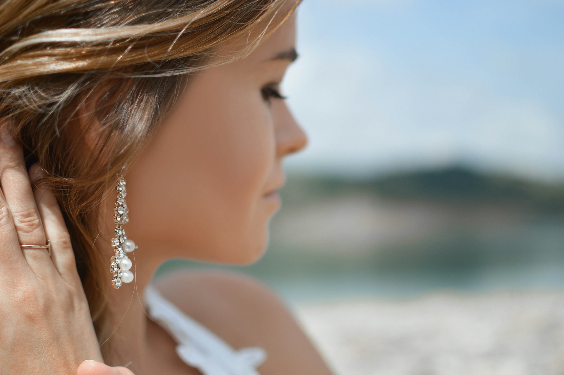Model wearing elegant pearl and crystal drop earrings